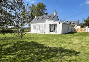 a white house with a large grassy yard at Chez Josie, cottage en Bretagne in Bannalec