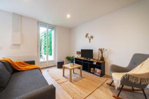 ラヴァルにあるLakaz - Maison - Jardin - Wifiのソファとテレビのあるリビングルーム