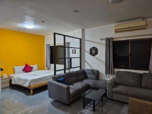 a living room with a couch and a bed at Dorothys in Pattaya South