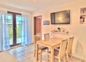 a dining room with a wooden table and chairs at Titania 3 in Grömitz