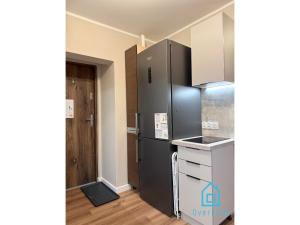 a kitchen with a stainless steel refrigerator in a room at Pink Panther Room 10 Min to Old Town Gdańsk,PKP & Shopping Mall in Gdańsk +19 photos