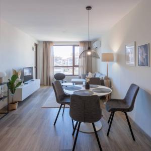 a living room with a couch and a table and chairs at Zerini Appartment in Burgas City