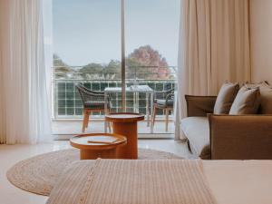 een woonkamer met een bank en een groot raam bij Aguas de Ibiza Grand Luxe Hotel - Small Luxury Hotel of the World in Santa Eularia des Riu +87 foto's