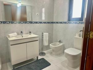 a white bathroom with a sink and a toilet at Azores Quinta do Segredo in Ponta Delgada +18 photos