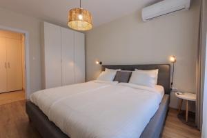 a bedroom with a large bed with white sheets at Zerini Appartment in Burgas City +14 photos
