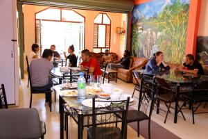a group of people sitting at tables in a restaurant at Siumi Rest in Adams Peak