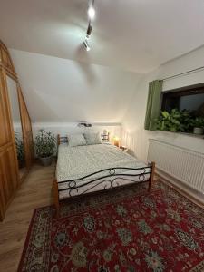 a bedroom with a bed and a red rug at Pokój Cień Paproci in Białla +21 photos