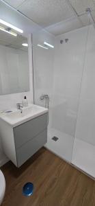 un bagno bianco con lavandino e specchio di Triana Apartahotel a Siviglia