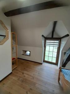 La Selle-CraonnaiseにあるRural Country Retreatのベッドと窓付きの屋根裏部屋