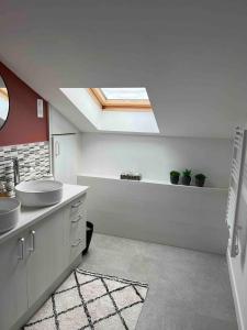 a bathroom with two sinks and a skylight at Maison Biscaya Appartement 6 personnes St Jean Pied de Port in Caro