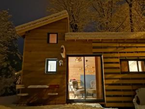 a log cabin with a table and chairs in the doorway at le Nid de la Monne in Le Vernet-Sainte-Marguerite