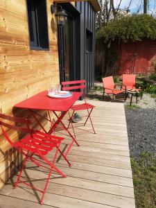a red table and chairs on a wooden deck at le Nid de la Monne in Le Vernet-Sainte-Marguerite +7 photos