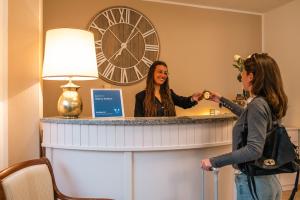 a woman is standing in front of a mirror at Hotel Ca' De Berna in Balestrino