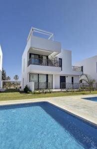 a house with a swimming pool in front of a house at Casa Nina Mar de Cristal in Mar de Cristal