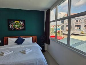 a bedroom with a bed and a large window at Dorothys in Pattaya South