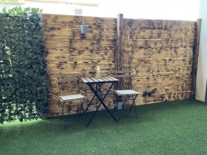 a table and two chairs in front of a wooden wall at L'Imperial in Arles