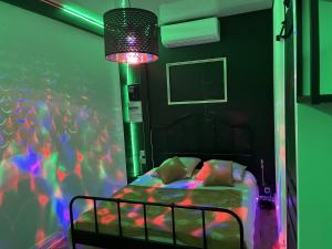 a bedroom with a bed with a purple and green lighting at L'Imperial in Arles