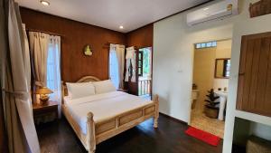 a bedroom with a white bed and a bathroom at Fa Sunset Cottage in Hinkong