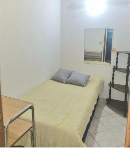 a bed with two pillows on it in a room at Departamento Batti in Asuncion