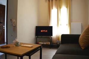 a living room with a tv and a coffee table at Helia Apartment 2 in Kanálion