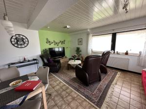 a living room with chairs and a flat screen tv at Apartment58 in Wiehl