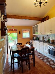 a kitchen with a wooden table and chairs in it at Casa dos Caseiros N2 in Vila Nova de Poiares