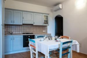 cocina con mesa blanca y armarios azules en Appartamento Panorama, en Tergu