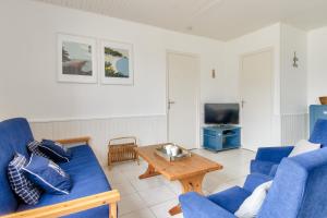 a living room with blue couches and a coffee table at Maison pour 10 avec jardin à Noirmoutier in Noirmoutier-en-l'lle