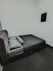 un letto nero con cuscini sul pavimento in una camera di MIA Hostel for Traveller a Simpang Kelemak