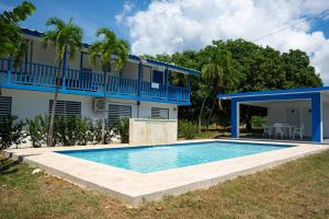 a swimming pool in front of a house at Ocean Village at Combate in Cabo Rojo