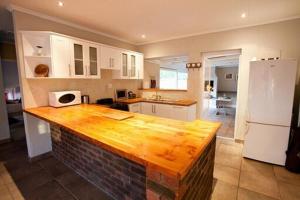 a kitchen with a wooden counter top in a room at Barking Beach Cottage, Sandbaai - Pet Friendly in Hermanus