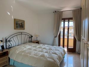 a bedroom with a bed and a door to a balcony at Tina's House in Certaldo