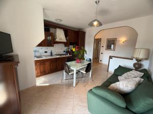 a living room with a green couch and a table at Tina's House in Certaldo