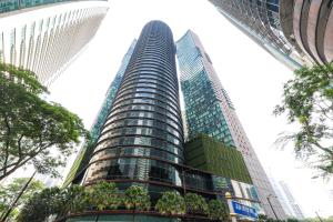 a tall building with palm trees in front of it at Sky Suites KLCC By Calm Sojourn in Kuala Lumpur