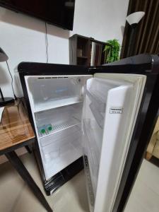 an empty refrigerator with its door open in a room at Dorothys in Pattaya South