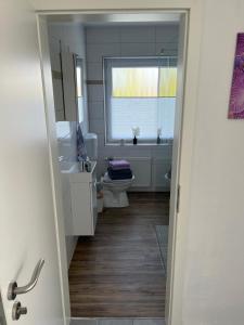 a bathroom with a toilet and a sink and a window at Ferienwohnung Käthe in Rhauderfehn