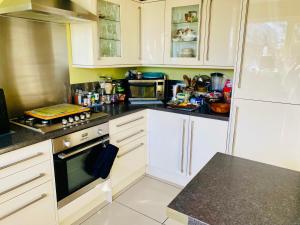 a kitchen with white cabinets and black counter tops at The Mansion Room in Manchester