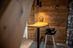 un tavolo e due sgabelli in una stanza con pareti in legno di Ferienhaus Fichtenzauber - Naturidylle am Wildgehege & Pfrunger Ried - Nähe Bodensee a Riedhausen