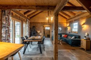 un soggiorno con un tavolo e un divano di Ferienhaus Fichtenzauber - Naturidylle am Wildgehege & Pfrunger Ried - Nähe Bodensee a Riedhausen
