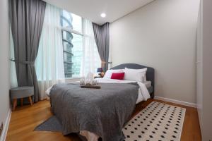 a bedroom with a bed and a large window at Sky Suites KLCC By Calm Sojourn in Kuala Lumpur