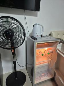 a black fan sitting next to a small refrigerator at Dorothys in Pattaya South