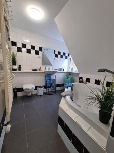 a bathroom with a tub and a toilet and a sink at Ferienwohnungen Dorfliebe Dörnberg TALBLICK in Bestwig