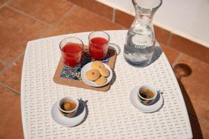 a table with two cups of tea and a tray of cookies at Old town apartment with sea view private rooftop in Giovinazzo