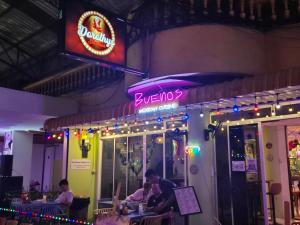 a restaurant with a neon sign and people sitting at tables at Dorothys in Pattaya South