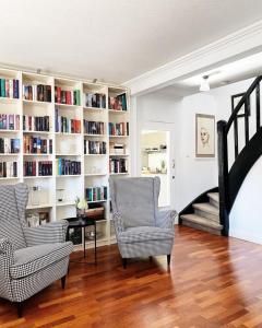 een woonkamer met 2 stoelen en een boekenplank bij Haus Cloude in Grömitz