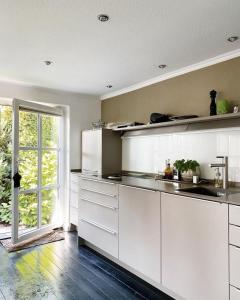 een keuken met witte kasten en een groot raam bij Haus Cloude in Grömitz