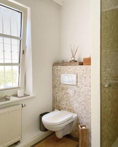 een badkamer met een wit toilet en een raam bij Haus Cloude in Grömitz +8 foto's