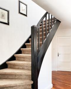 een trap in een huis met zwarte en witte muren bij Haus Cloude in Grömitz