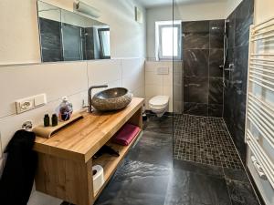 a bathroom with a sink and a shower at Ours Living Venedigerblick - inkl Sauna in Hollersbach im Pinzgau