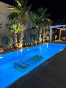 a swimming pool at night with palm trees at Villa Azul in Palasë